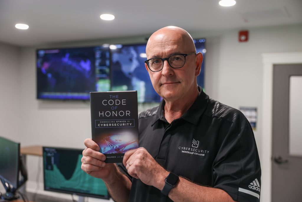 Paul Maurer holds Code of Honor book