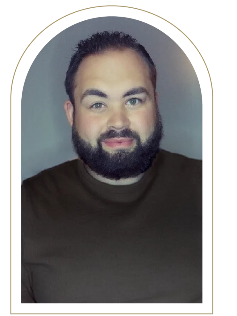 Photo of a middle-aged man with a black beard in a brown shirt